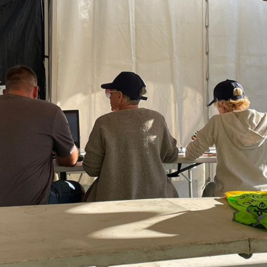 Expertise stratégique : Laurence et Nadège de dos, en pleine session de travail avec le Président de la Ligue LAMAURA lors de la Coupe Icare. Focus sur l'accompagnement premium et les solutions sur mesure pour votre croissance.